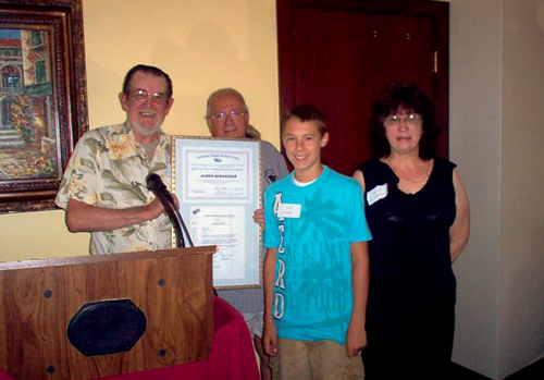 Duke accepting award with grandson and wife